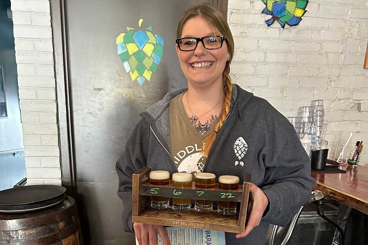 Server at Brewery holding beer sampler tray